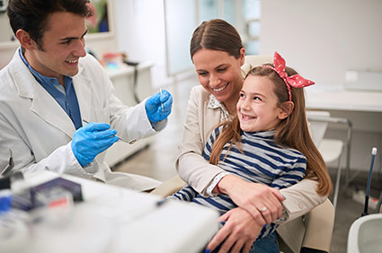 Dentist helping a woman and her child