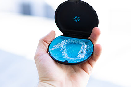 holding an Invisalign container